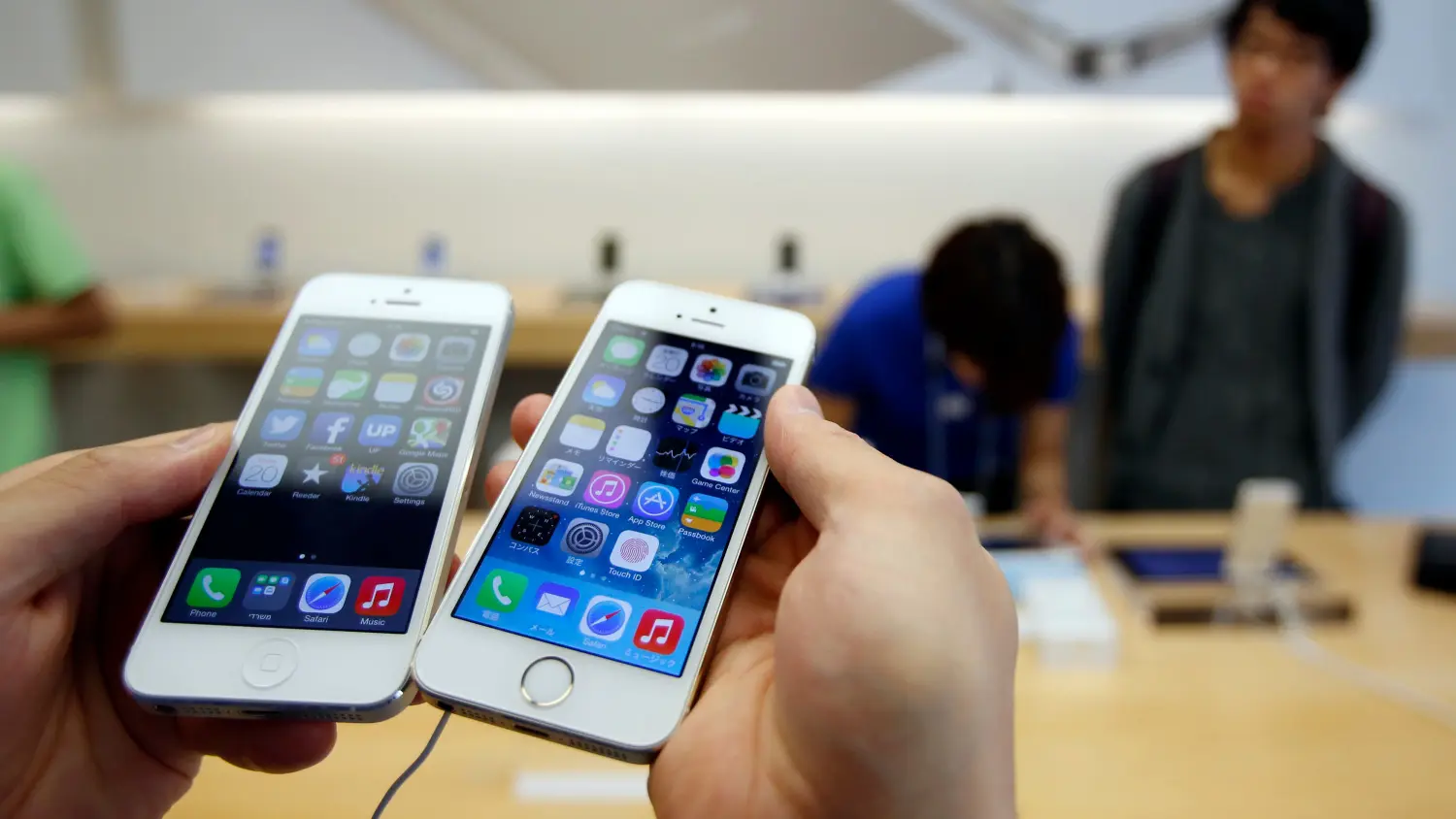 A man holds a new Apple iPhone 5S next to his iPhone 5 at an Apple Store at Tokyo's Ginza shopping district