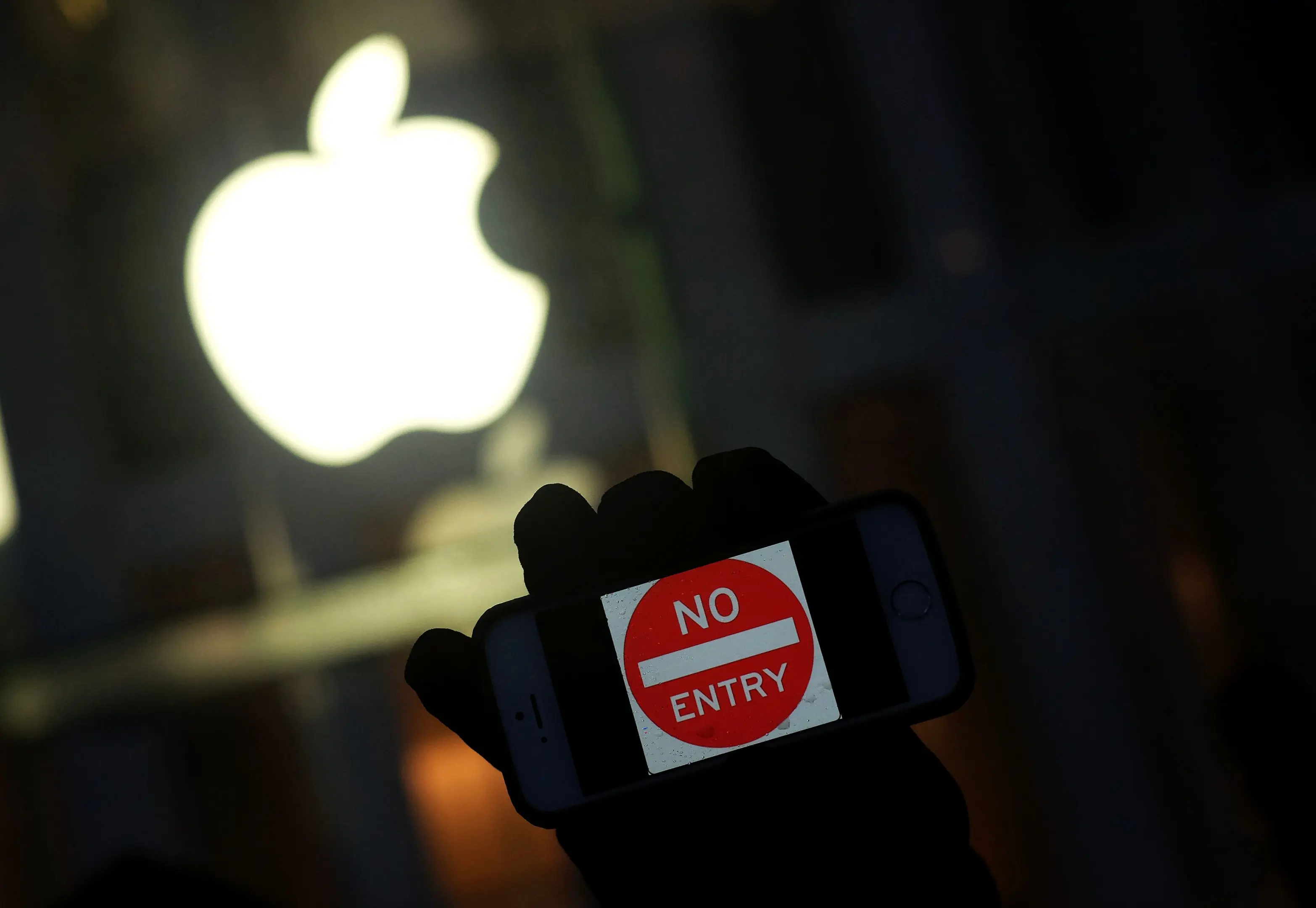 (FILES) This file photo taken on February 23, 2016 shows an anti-government protester holding his iPhone with a sign "No Entry" during a demonstration near the Apple store on Fifth Avenue in New York. The US Justice Department on March 21, 2016 filed a request to postpone a crucial hearing with Apple on accessing the iPhone of one of the San Bernardino attackers, citing new leads in the case. "On Sunday, March 20, 2016, an outside party demonstrated to the FBI a possible method for unlocking (Syed) Farook's iPhone, " prosecutors said in a filing. "Testing is required to determine whether it is a viable method that will not compromise data on Farook's iPhone. "If the method is viable, it should eliminate the need for the assistance from Apple Inc. set forth in the All Writs Act Order in this case." Prosecutors requested that Tuesday's hearing before a federal judge in California be cancelled in order to allow time for testing the new method, and proposed filing a status report with the court by April 5. The high-stakes case has pitted Apple against the FBI, which sought the tech giant's help in unlocking the iPhone of Farook, who, along with his wife, was behind the December 2 terror attack in San Bernardino that left 14 people dead. jz/oh / AFP PHOTO / Jewel Samad